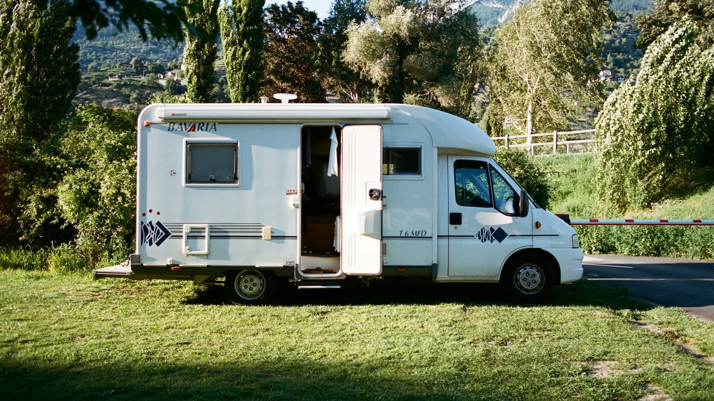 Autocaravana estacionada en una parcela de camping con la puerta abierta